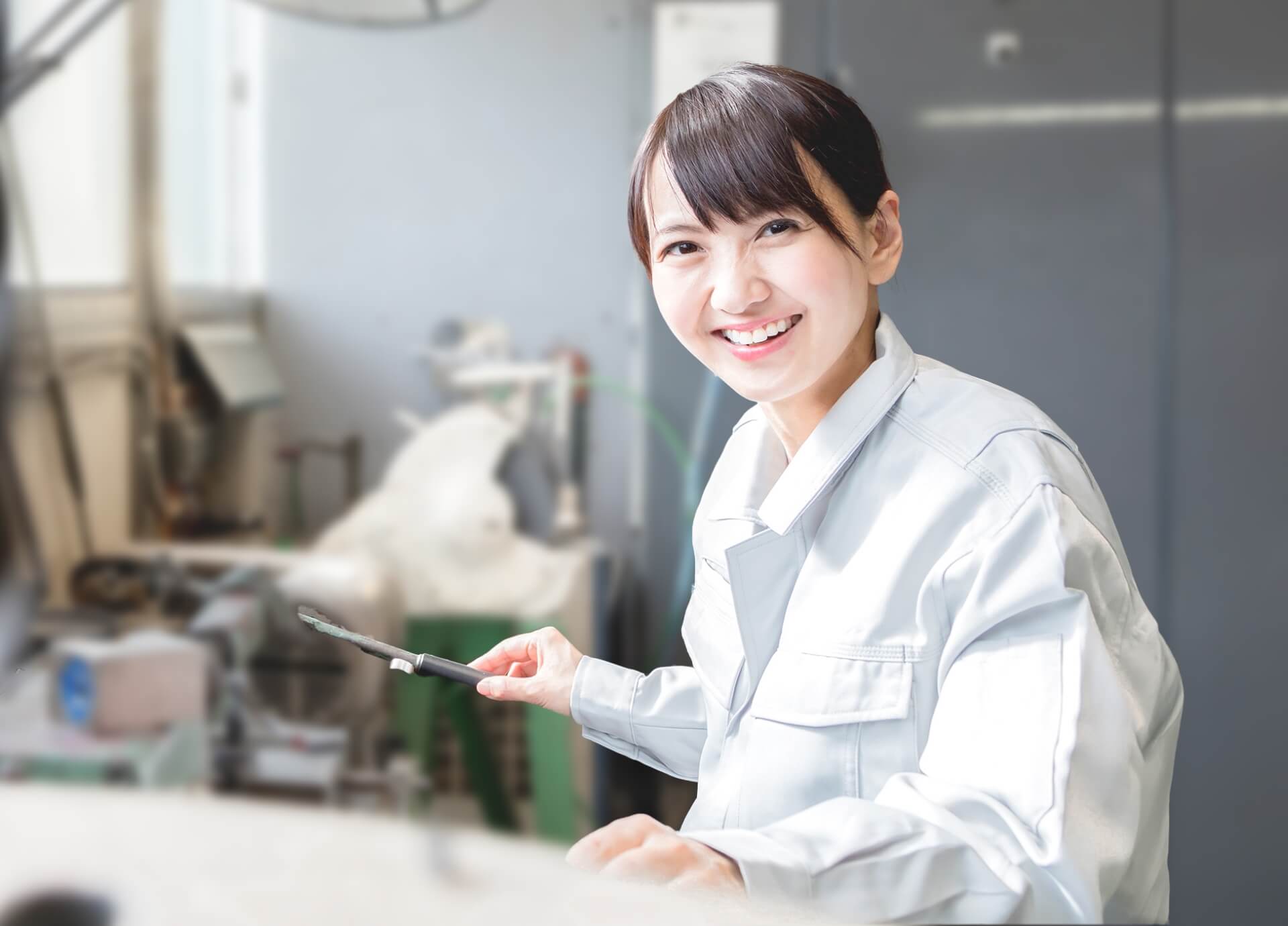 機械を操作する笑顔の女性社員