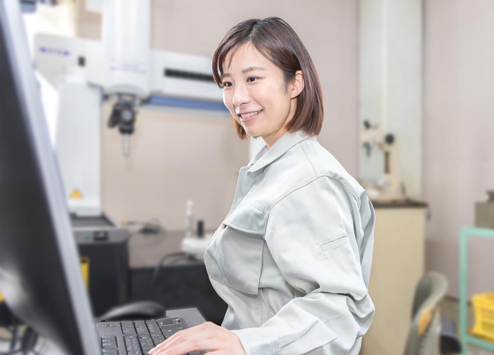機械を操作する笑顔の女性社員