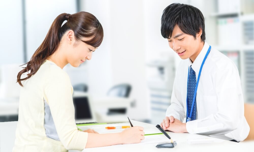 男性社員と書類に記入する女性