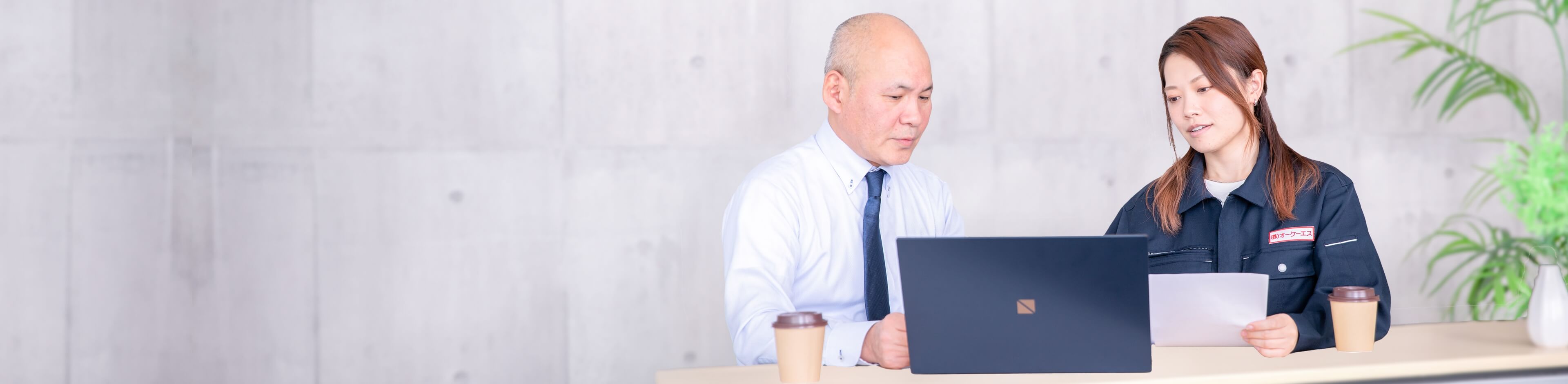 パソコンを見ながら会話する男女社員
