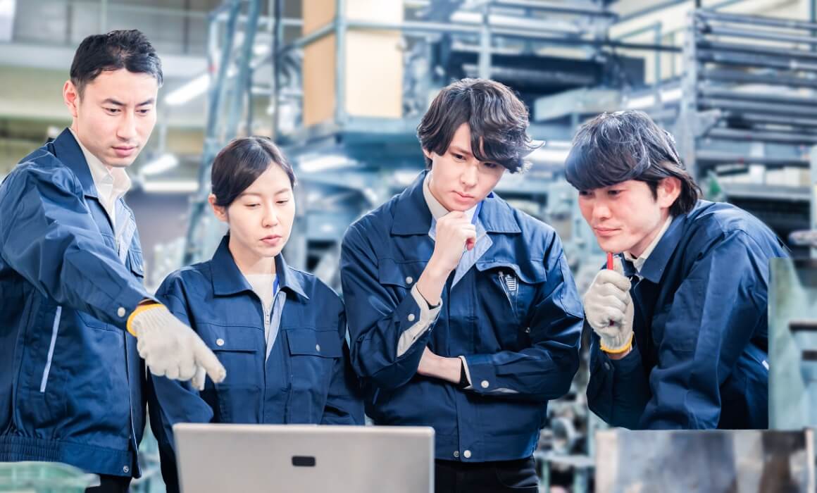 会話する作業服姿の社員たち